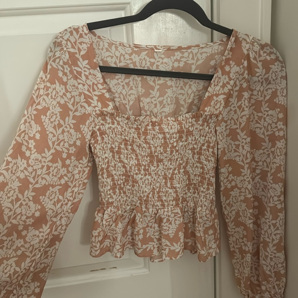 Coral/light pink and white floral flowy top with loose sleeves.